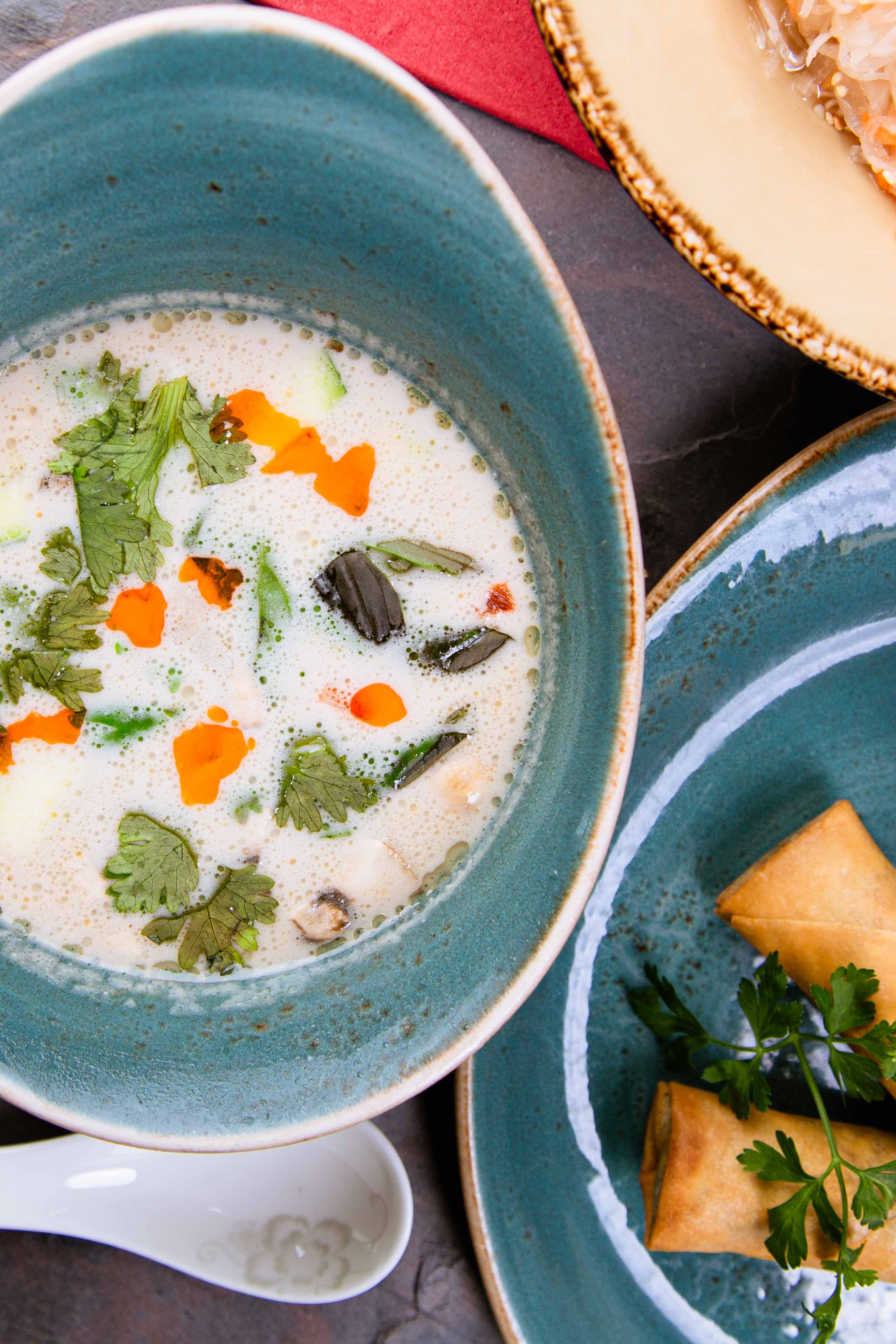 Eine helle Kokosgalgant Suppe mit Chiliöl tropfen.